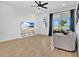Living room with a ceiling fan, tile floors, large window, sliding glass doors, and couch at 3280 Canna Lily Pl, Clermont, FL 34711