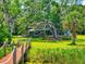 Expansive backyard featuring a well-maintained lawn, mature trees, and a charming path leading to the home at 3443 S Mellonville Ave, Sanford, FL 32773