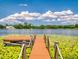 Scenic view of a dock leading to a lake with lush greenery and a blue sky at 3443 S Mellonville Ave, Sanford, FL 32773