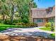Paver driveway leading to the house with lush greenery and mature trees at 3443 S Mellonville Ave, Sanford, FL 32773