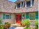 Exterior of a two-story home with red front door, green shutters, and lush landscaping at 3443 S Mellonville Ave, Sanford, FL 32773