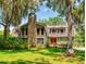 Charming home with a stone chimney, red front door, and lush landscaping at 3443 S Mellonville Ave, Sanford, FL 32773