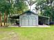 Exterior of the outbuilding, showing parking and storage for the property, amidst a tranquil setting at 3443 S Mellonville Ave, Sanford, FL 32773