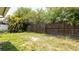 Backyard with a wood fence, grass, weeds, and trees at 4236 Newtonhall Dr, Orlando, FL 32826