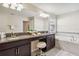 Bathroom with double sinks, granite counters, tiled floors and a relaxing soaking tub at 4740 Sleepy Hollow Dr, Kissimmee, FL 34746