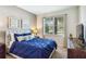 This bedroom has a bed with an upholstered headboard, two wall hangings, and a window at 4740 Sleepy Hollow Dr, Kissimmee, FL 34746