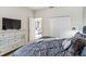 Cozy bedroom with a plush comforter, dresser with TV, and access to another room at 4740 Sleepy Hollow Dr, Kissimmee, FL 34746