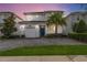 Beautiful two-story home with a blue front door, lush landscaping, and a brick driveway at 4740 Sleepy Hollow Dr, Kissimmee, FL 34746