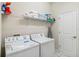 Functional laundry room with a washer, dryer, wire rack shelf, and cleaning supplies ready for use at 4740 Sleepy Hollow Dr, Kissimmee, FL 34746