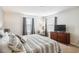 Bright main bedroom with a king bed, a side chair, side table, dresser, and tv at 4740 Sleepy Hollow Dr, Kissimmee, FL 34746