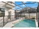 Backyard view of a screened-in pool and spa, with safety fence and clear blue water at 4740 Sleepy Hollow Dr, Kissimmee, FL 34746