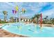 Community splash pad with bucket drop feature surrounded by lounge chairs and lush landscaping at 4740 Sleepy Hollow Dr, Kissimmee, FL 34746