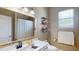 Bright bathroom featuring a white vanity, decorative mirror, and window at 6198 Linneal Beach Dr, Apopka, FL 32703