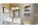 Bathroom featuring a white vanity, decorative mirror, and stylish open shelving at 6198 Linneal Beach Dr, Apopka, FL 32703