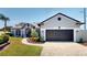 Charming single-story home featuring a well-manicured lawn, beautiful landscaping, and a two-car garage at 6198 Linneal Beach Dr, Apopka, FL 32703