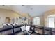A living room offers an open floor plan with wood floors, neutral walls, and a kitchen with barstool seating in the background at 6198 Linneal Beach Dr, Apopka, FL 32703