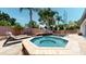 A backyard swimming pool and spa are surrounded by palm trees and a stone deck, creating a tropical oasis at 6198 Linneal Beach Dr, Apopka, FL 32703