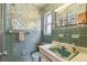 Retro bathroom featuring blue tiles, a mirror, and a decorative wallpaper, creating a vintage charm at 620 Marshall St, Altamonte Springs, FL 32701