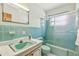 Retro bathroom featuring blue tiles, a glass shower enclosure and a matching vanity, offering a vintage charm at 620 Marshall St, Altamonte Springs, FL 32701
