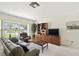 Living room featuring large window, plush seating, a wooden entertainment center, and neutral colors at 620 Marshall St, Altamonte Springs, FL 32701