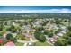 Overhead shot showcasing the community layout with winding streets, diverse rooftops, mature trees and a vast green space at 620 Wood Dr, Kissimmee, FL 34759
