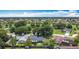 Expansive aerial view of a residential community featuring lush greenery and well-maintained homes under a bright blue sky at 620 Wood Dr, Kissimmee, FL 34759
