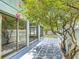 Enclosed back patio featuring tiled floors, a white fence, mature trees, and sliding glass doors for indoor-outdoor living at 620 Wood Dr, Kissimmee, FL 34759
