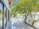 Back patio showcases tiled floors, white picket fence, mature trees, and beautiful bougainvillea for relaxing outdoor living at 620 Wood Dr, Kissimmee, FL 34759
