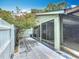Enclosed back patio featuring tiled floors, a white fence, mature trees, and sliding glass doors for indoor-outdoor living at 620 Wood Dr, Kissimmee, FL 34759