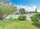 Spacious backyard features well-manicured lawn, mature trees, and a white fence creating a private and serene outdoor oasis at 620 Wood Dr, Kissimmee, FL 34759