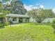 Expansive backyard with lush green grass, mature trees, and a white fence, perfect for outdoor activities and relaxation at 620 Wood Dr, Kissimmee, FL 34759