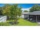 Lush backyard featuring screened lanai, seating, and well-maintained lawn at 620 Wood Dr, Kissimmee, FL 34759