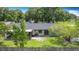 Overhead view of a home's backyard with trees, patio, and well-manicured lawn at 620 Wood Dr, Kissimmee, FL 34759
