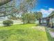 Spacious backyard with well-maintained lawn, mature trees, white fence, and screened-in porch at 620 Wood Dr, Kissimmee, FL 34759