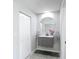 Bathroom featuring a modern vanity with a round mirror and stylish fixtures at 620 Wood Dr, Kissimmee, FL 34759
