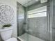 Modern bathroom features a glass enclosed shower with gray marble-style tiles and updated fixtures at 620 Wood Dr, Kissimmee, FL 34759