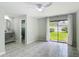 Bright bedroom with en-suite bathroom featuring tile floors and sliding glass door to the backyard at 620 Wood Dr, Kissimmee, FL 34759