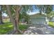 Well-maintained home featuring a two-car garage, complemented by a green lawn and mature trees for added curb appeal at 620 Wood Dr, Kissimmee, FL 34759