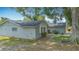 Detailed side exterior of a home featuring stone accents, mulch landscaping, and a pathway leading to a gated entrance at 620 Wood Dr, Kissimmee, FL 34759