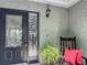 Inviting front porch featuring a stylish glass front door, chair, and decorative plants at 620 Wood Dr, Kissimmee, FL 34759