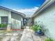 Inviting home entrance with a decorative gate, potted plants, and stone accents, set against a neatly landscaped front yard at 620 Wood Dr, Kissimmee, FL 34759