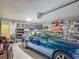 Cluttered garage with storage shelves, car, and tools; practical and functional space at 620 Wood Dr, Kissimmee, FL 34759