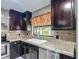This kitchen features dark cabinetry, granite countertops, tile backsplash, and stainless steel appliances at 620 Wood Dr, Kissimmee, FL 34759