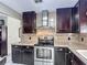 Spacious kitchen featuring dark cabinetry, granite countertops, stainless steel range and tile backsplash at 620 Wood Dr, Kissimmee, FL 34759