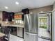 Well-lit kitchen with stainless steel appliances, dark cabinetry, and granite countertops at 620 Wood Dr, Kissimmee, FL 34759