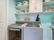 Bright laundry room boasts modern machines, ample shelving, and stylish storage solutions for an organized and efficient space at 620 Wood Dr, Kissimmee, FL 34759