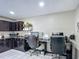 Home office area featuring dark cabinetry, granite countertops, two work stations and tile flooring at 620 Wood Dr, Kissimmee, FL 34759