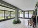 This sunroom has tiled floors, lots of light, and views of the fenced backyard at 620 Wood Dr, Kissimmee, FL 34759