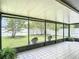 Enclosed patio showing tiled floors, screened windows and lawn chairs, with views of the fenced in backyard at 620 Wood Dr, Kissimmee, FL 34759