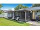 Home exterior with a screened-in porch including seating and views of the landscaped backyard at 620 Wood Dr, Kissimmee, FL 34759